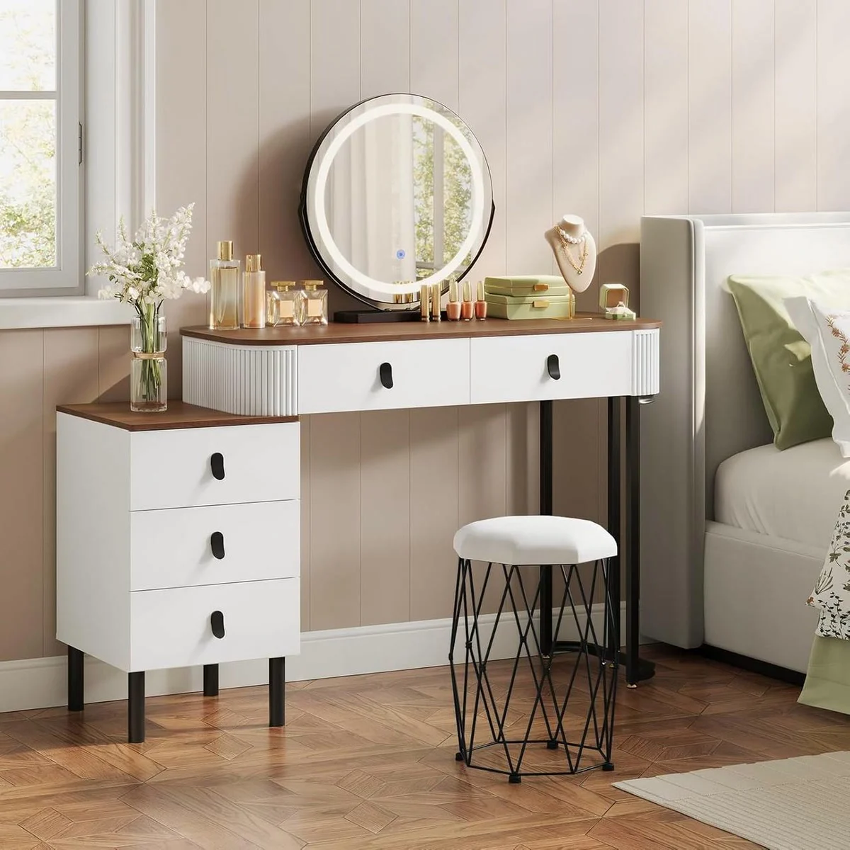 Coiffeuse bois et blanc dans une chambre, miroir rond allumé, commode et tabouret en velours