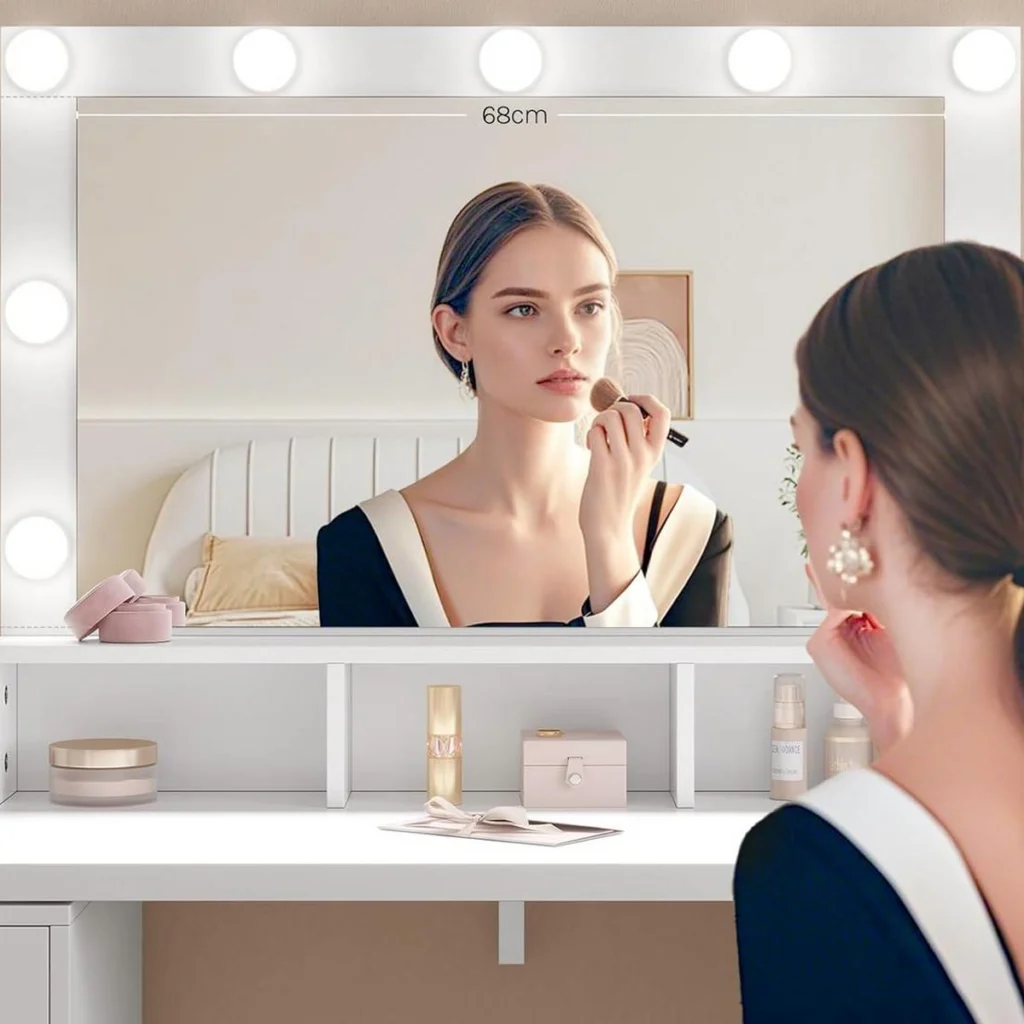 Une femme se maquille devant le miroir à 9 ampoules